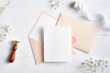 © photoguns - Elegant wedding stationery set. Wedding invitation cards template, pastel pink envelopes, silk ribbon, wax seal stamp, flowers on stone table. Flat lay, top view, copy space.