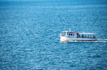 Sticker - White taxi boat passing on the open sea from the Rovinj port in the calm weather during winter