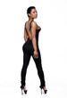  Studio portrait of an African American female wearing  a very tight one piece black outfit and over her shoulder.