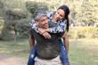 © G-images - Happy couple enjoying piggyback ride in park