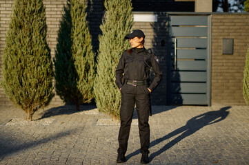 Wall Mural - Woman police officer on street full-length portrait