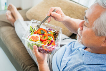 Mature man with pumpkin and healthy food, Portrait Asian Senior man eating a salad in house, Old elderly male health care eat vegetables and useful foods.