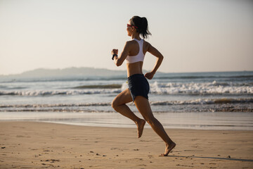 Wall Mural - Fitness woman running on beach