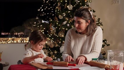 Poster - family, cooking and winter holidays concept - happy mother and baby daughter with rolling pin and dough for gingerbread cookies making high five gesture at home on christmas