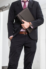 Black leather business padfolio portfolio folder held by man in business suit