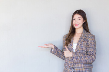 Asian professional woman with black long hair wearing a plaid suit and pretty smiling looking at camera is present product on white background.