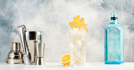 Gin mule trendy cocktail with dry gin, lemon juice, soda, lime and ginger. Gray counter background with copy space