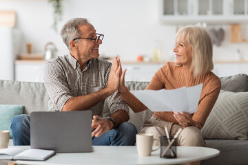 Wall Mural - Mature Couple Holding Papers And Giving High-Five Reading Bills Indoors