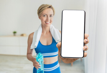 Fitness Online. Smiling Middle-Aged Woman In Sportswear Demonstrating Blank Smartphone At Camera