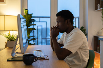 Pensive freelance web developer thoughtful working on new application software or website interface serious looking at computer monitor. Remote it specialist coder try to find error in code of app