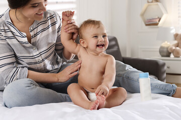 Wall Mural - Mother applying dusting powder on her cute baby at home