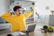 © Prostock-studio - Asian male student yawning sitting at desk with pc