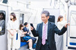 © maroke - 電車内でメールを送るビジネスマン