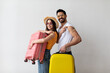 © Prostock-studio - Ready for travel. Young vaccinated couple showing shoulders with band aid after Covid-19 vaccine, holding suitcases