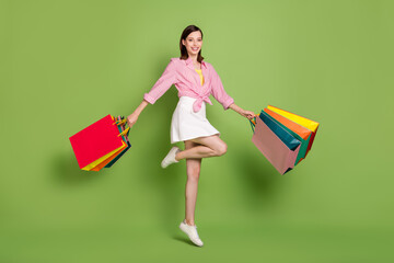 Wall Mural - Full size picture of smiling glad shopaholic woman go shopping spring time weekend isolated on green color background