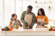 © Prostock-studio - Black Family Cooking Together Making Salad Standing In Modern Kitchen
