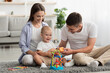 © Prostock-studio - Happy Parents And Adorable Infant Baby Playing With Development Toys At Home