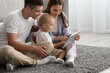 © Prostock-studio - Online Shopping. Young Parents And Infant Baby Using Digital Tablet At Home