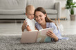 © Prostock-studio - Loving Young Mom Reading Book For Her Adorable Infant Son At Home