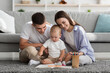 © Prostock-studio - Mother, Father And Cute Toddler Son Painting Together At Home