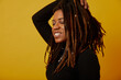 Studio shot of woman with dreadlocks against yellow background