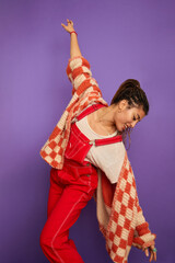 Studio shot of woman in white and red clothing against purple background