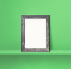 Poster - Wooden picture frame leaning on a green shelf. 3d illustration. Square background