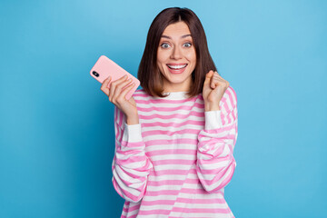 Canvas Print - Photo of impressed young brunette lady hold telephone yell wear striped pullover isolated on blue background