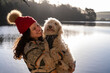 © Cultura Creative - Young woman holding dog at lake