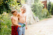 © Iryna - Children having garden hose fun in back yard.