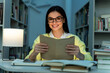 © NFstock - Photo of young amazed woman feeling excited while reading book with happy smile at the evening at the library. Stock photo