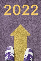 Wall Mural - New year 2022 or start straight concept. word 2022 written on the asphalt road and feet