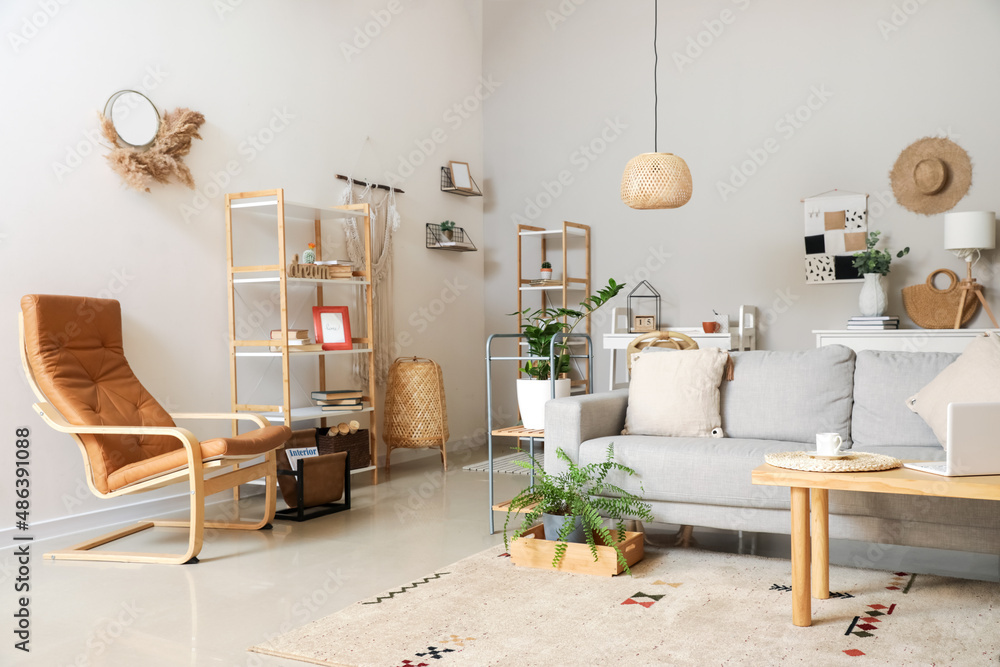 Interior of modern room with stylish sofa and laptop on table