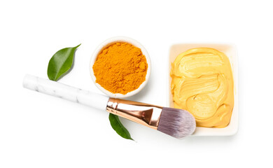 Wall Mural - Bowls with turmeric mask, powder and makeup brush on white background