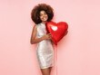 © Oleg Gekman - A beautiful young African-American woman with heart shape air balloon on a pink background. Woman on Valentine's Day. Symbol of love