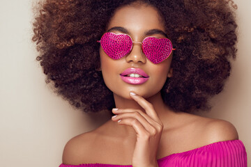 Beautiful portrait of an African girl in sunglasses in the shape of hearts. Valentine's Day. Symbol of love