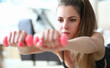 © H_Ko - Portrait of young lying woman with dumbbells