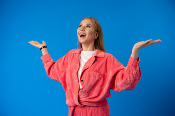 Excited thrilled woman portrait on blue studio background