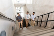 © Syda Productions - business, people and corporate concept - group of men with conference badges, folder, tablet pc computer and smartphone walking up office stairs