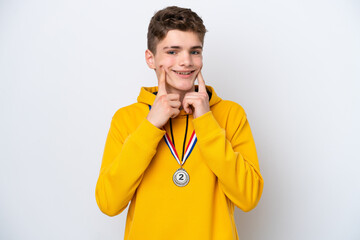 Teenager Russian man with medals isolated on white background smiling with a happy and pleasant expression