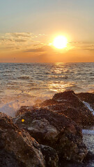 Wall Mural - colorful sunset with large sun under the sea waves.