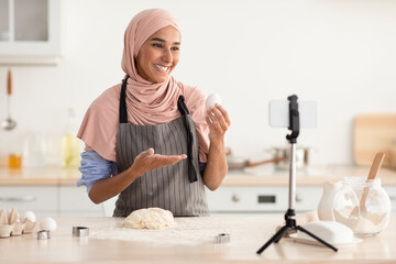 Wall Mural - Food Blogging. Beautiful Muslim Lady In Hijab Baking On Camera In Kitchen