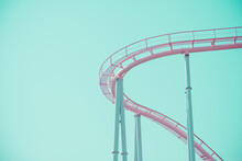 Pink Pastel Looping Roller Coaster On Blue Sky Sunny Day Retro Tone. Enjoy Travel Holiday Concept.