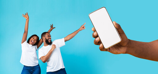 Black couple showing blank empty smartphone screen for mockup