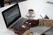 © Svyatoslav Lypynskyy - Young african freelancer man working on laptop while enjoying cup of coffee with smartphone next to him. African student study using laptop while coffee break at campus. Close up hands with laptop