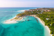 Many boats on the ocean coast and thin strip of sandy beach, palm trees. View from above on the turquoise water. Drone photo 