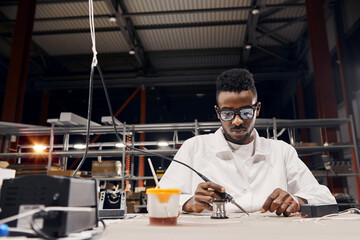 Wall Mural - african engineer using soldering iron at factory