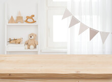 Wooden Desk On Blurred Child Room Or Kindergarten Interior Background