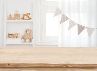 Wall Mural - wooden desk on blurred child room or kindergarten interior background