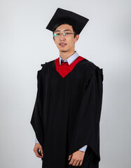 Wall Mural - Graduate in glasses wearing gown and mortarboard on a white background